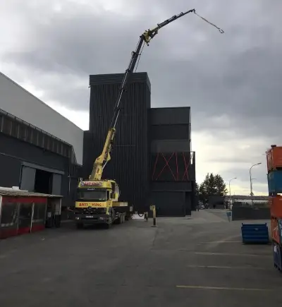 Fabrika binasının yanında kurulmuş vinçle makine taşıma operasyonu
