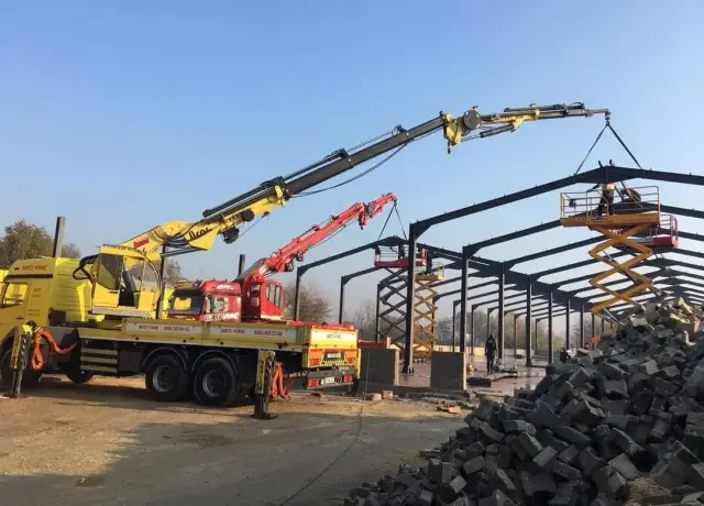 İki vincin eş zamanlı olarak çelik çatı konstrüksiyonunu kaldırması